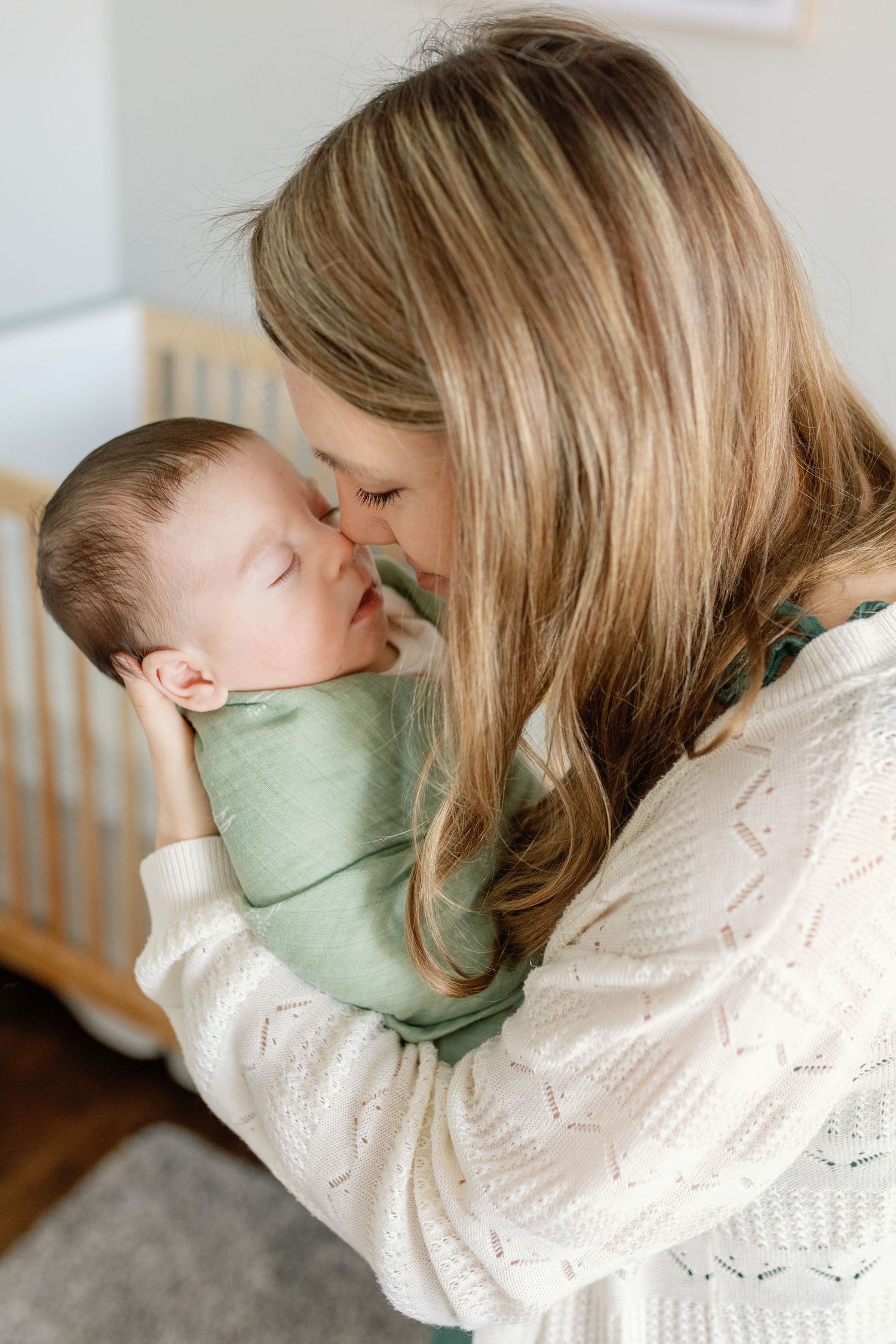 Tender moments captured between parent and baby in soft natural lighting.