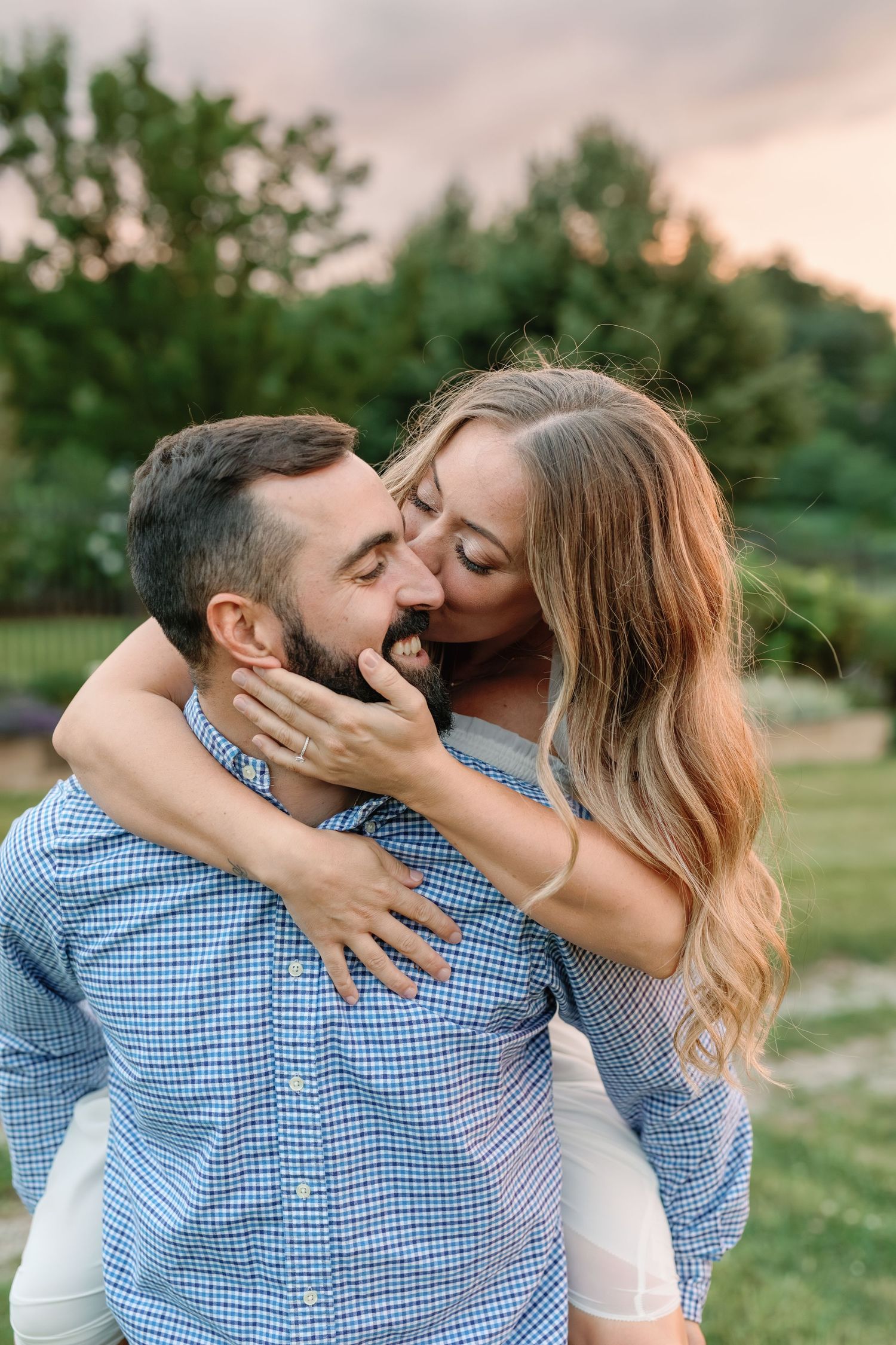 Romantic couple sharing intimate moments in a garden setting wearing blue and white.