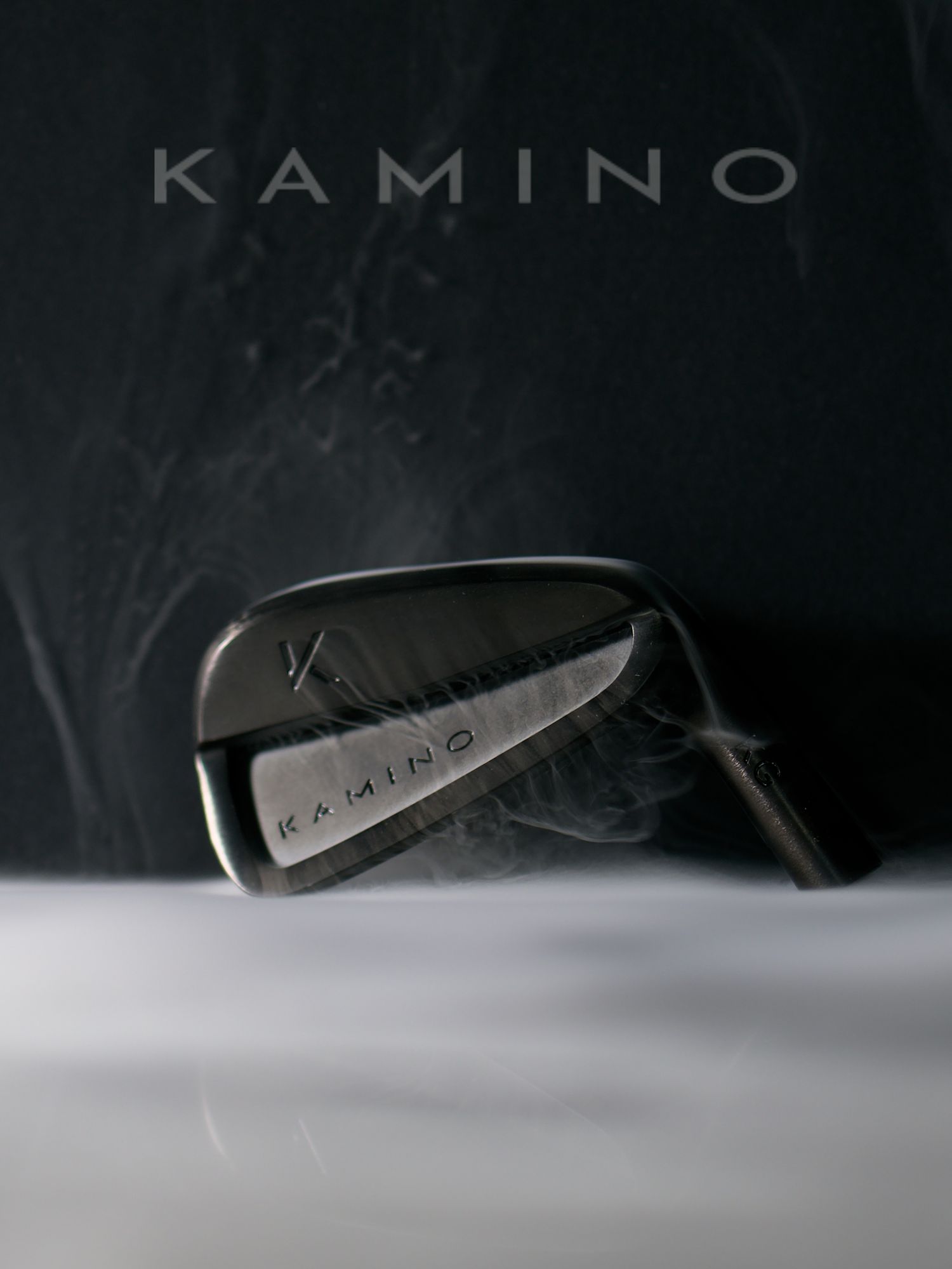 Kamino Golf iron club head with smoke effect against dark slate background with brand name.
