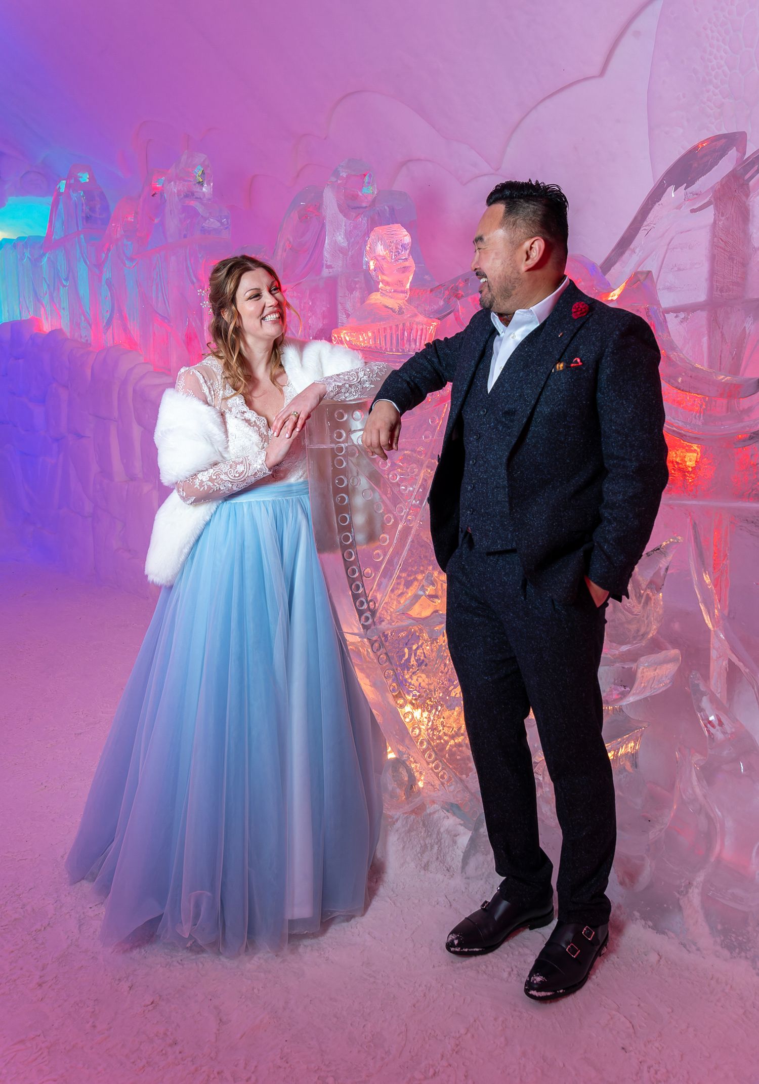 Bride and groom posing in the illuminated Ice Hotel, Hôtel de Glace, near Quebec City