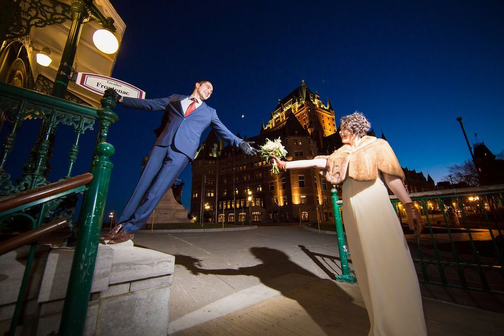 A dramatic night wedding photo on an ornamental terrace in Old Quebec with Château Frontenac in the background