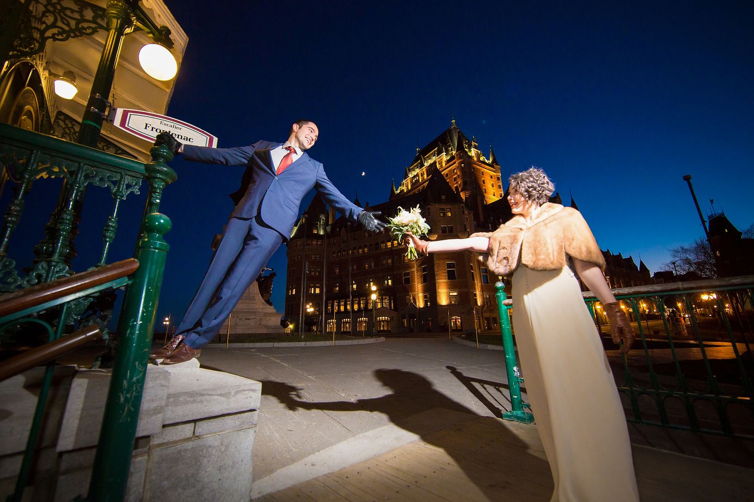 A dramatic night wedding photo on an ornamental terrace in Old Quebec with Château Frontenac in the background