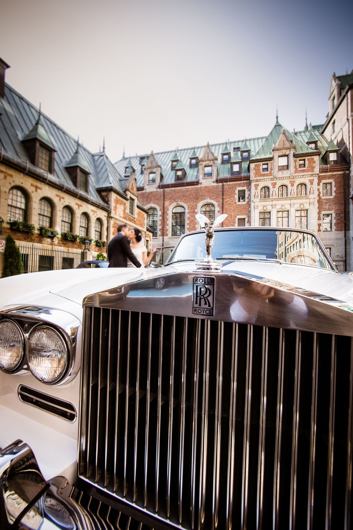 Classic vintage wedding car parked in front of a historic castle venue in Quebec City