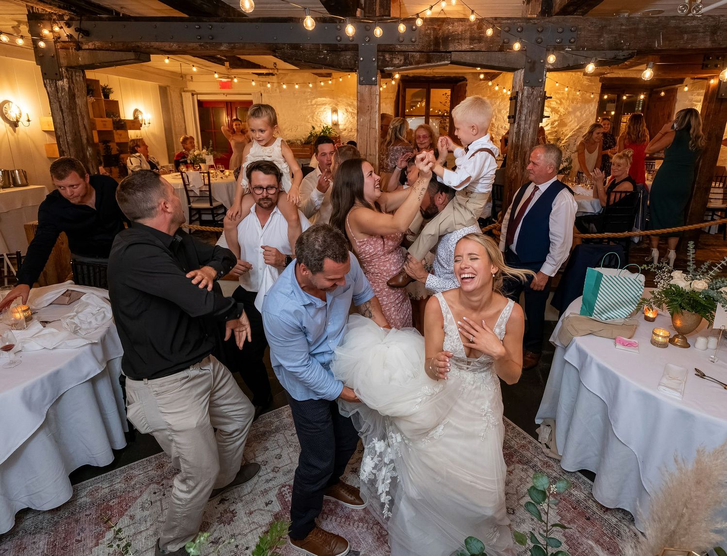 Lively candid moment of wedding guests dancing at a rustic log cabin reception in Quebec
