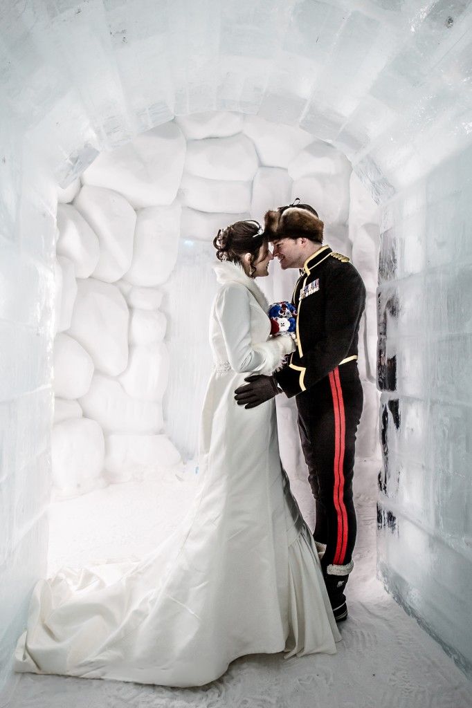 Full-length wedding couple portrait in formal attire standing in an ice archway at Hôtel de Glace