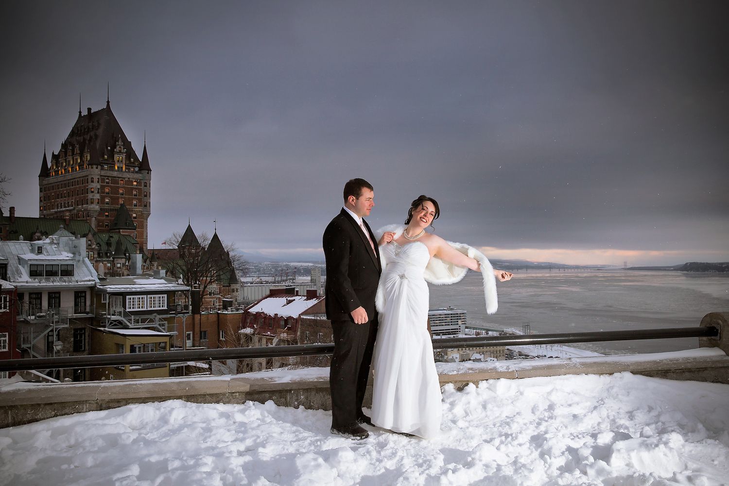 A winter wedding couple on the Terrasse Dufferin with a stunning view of Château Frontenac in Old Quebec City