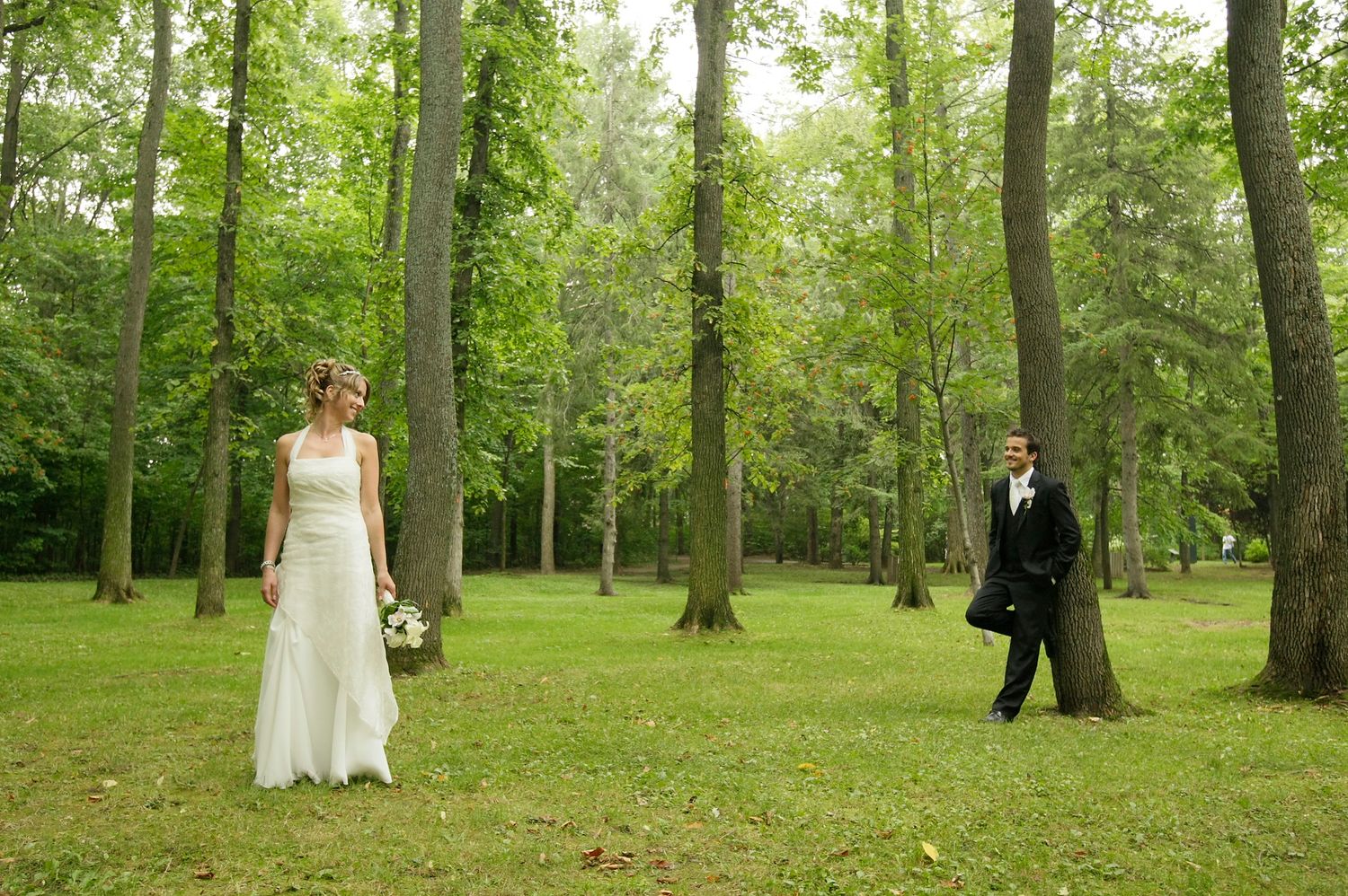 Scenic outdoor bride and groom portrait surrounded by lush green trees in Quebec