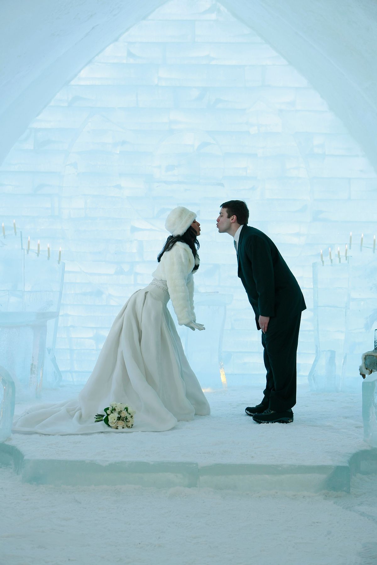 Bride and groom kissing inside the crystal ice chapel at the Hôtel de Glace, Quebec