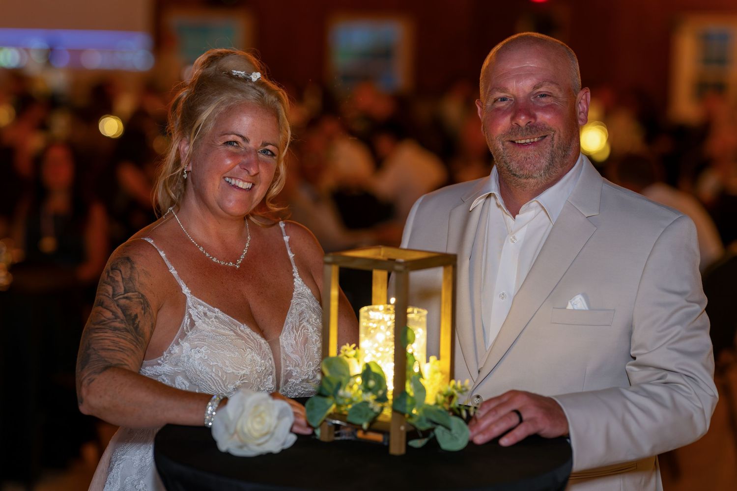 A joyful intimate portrait of a wedding couple with a candlelit table setting at their reception in Quebec City