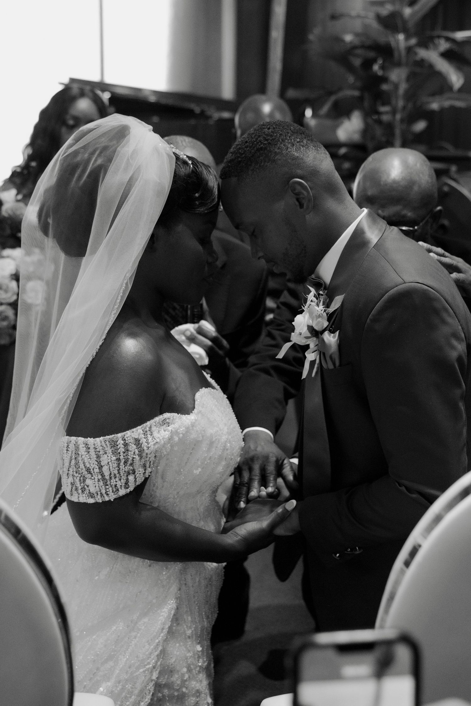 Black and white photo of a bride and groom sharing an intimate moment during their wedding ceremony.
