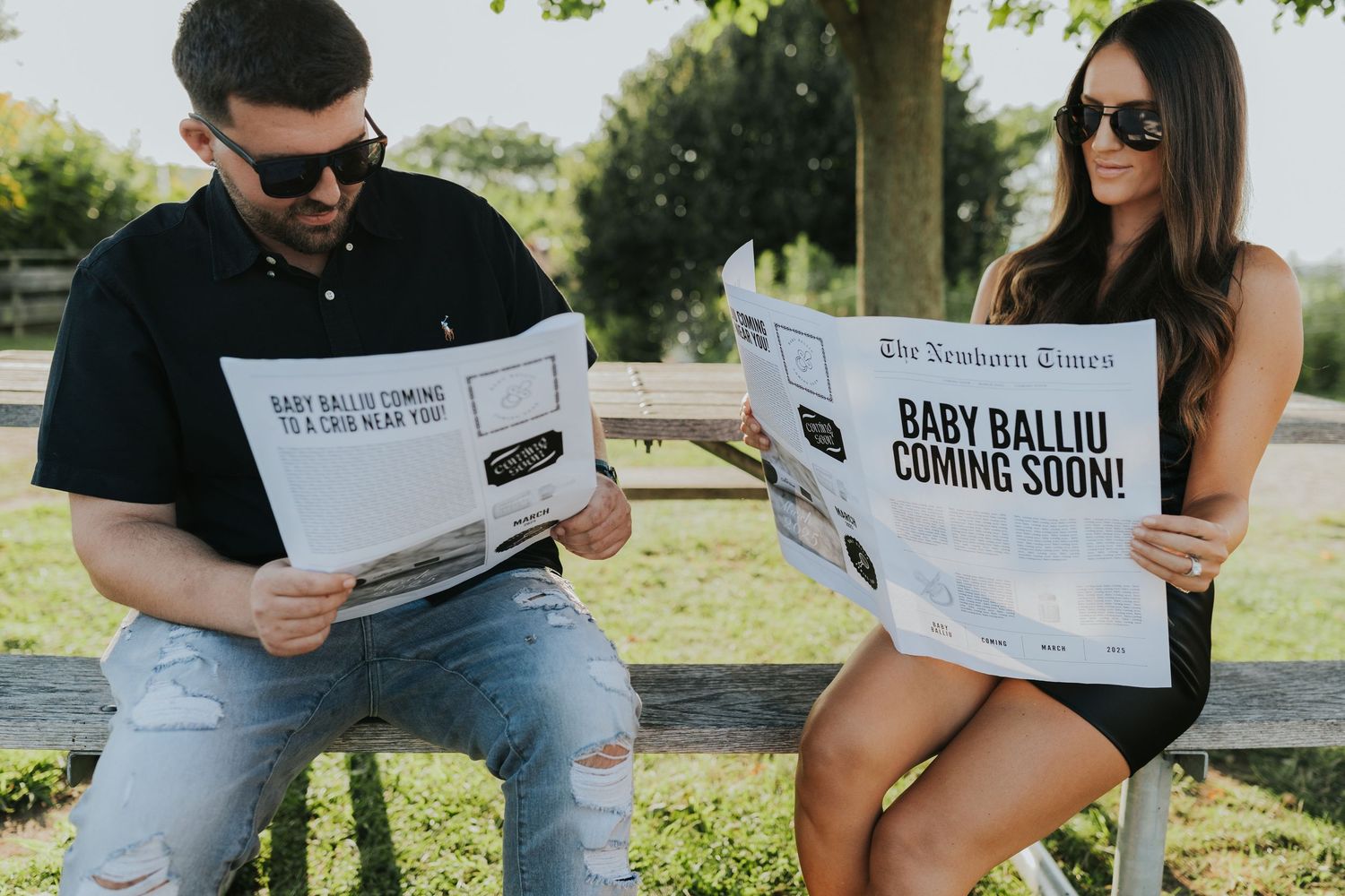 Couple reading newspapers announcing Baby Balliu coming soon, fun pregnancy announcement outdoors.