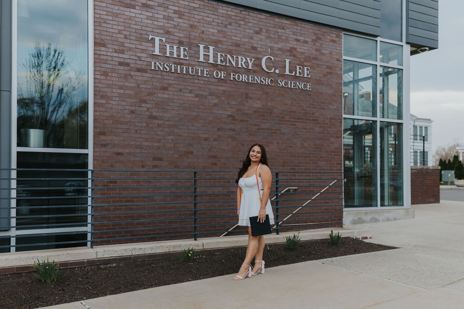 Young woman standing in front of The Henry C. Lee Institute of Forensic Science building.