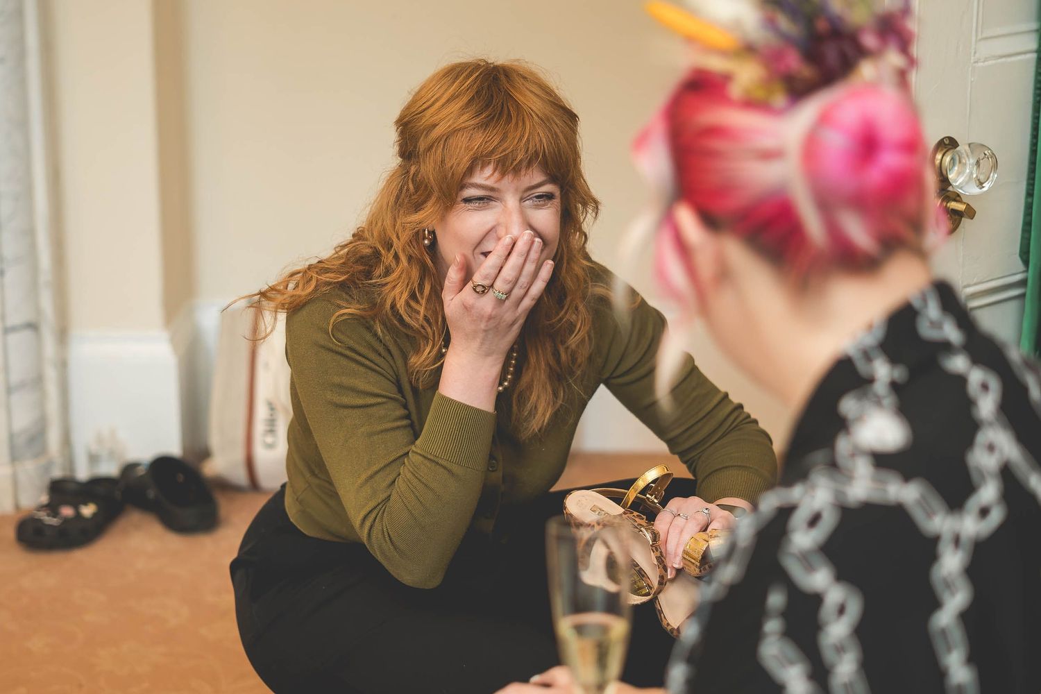 A bridesmaid laughing naturally during bridal prep at a wedding in Durham