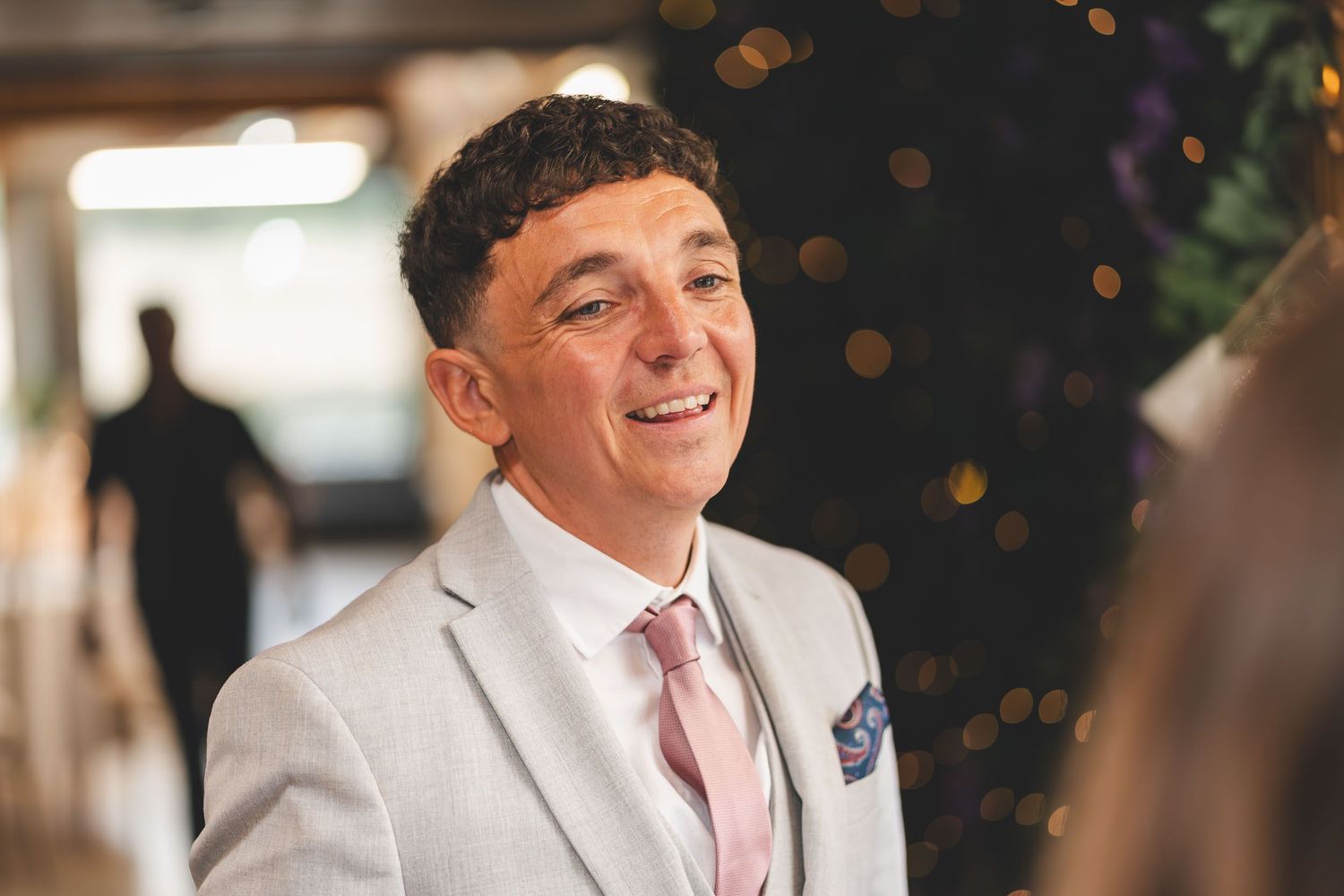 a wedding guest smiling near Preston