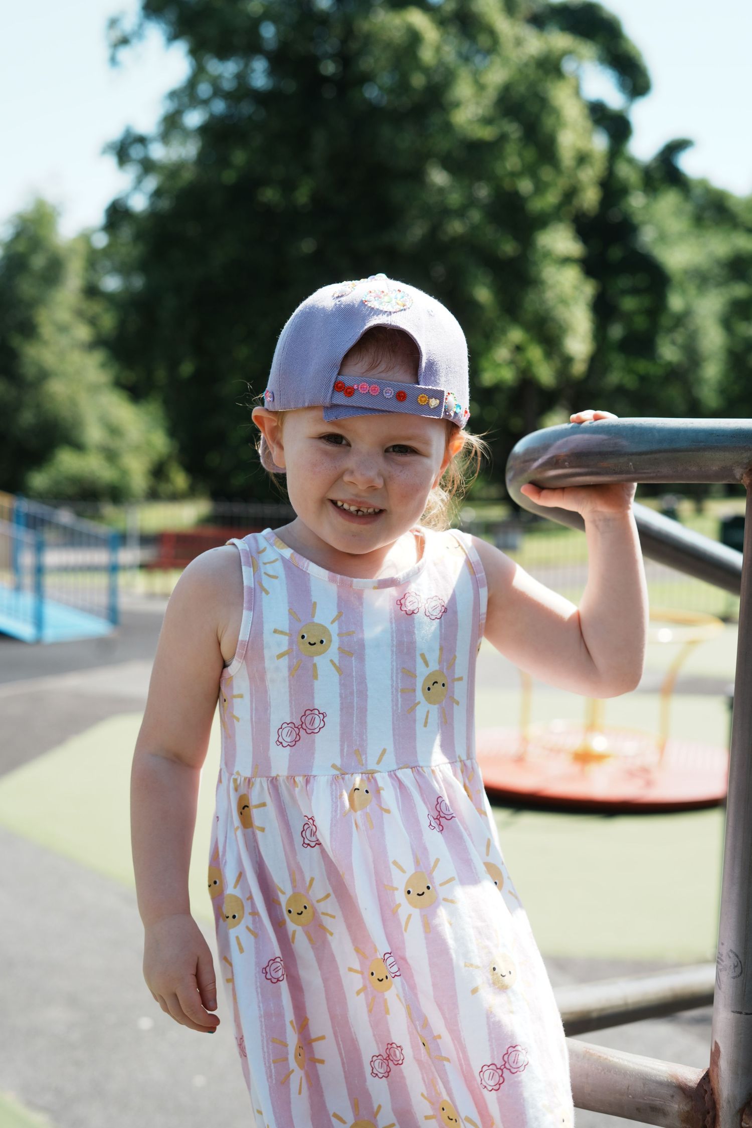 A child in a baseball cap smiles in Accrington
