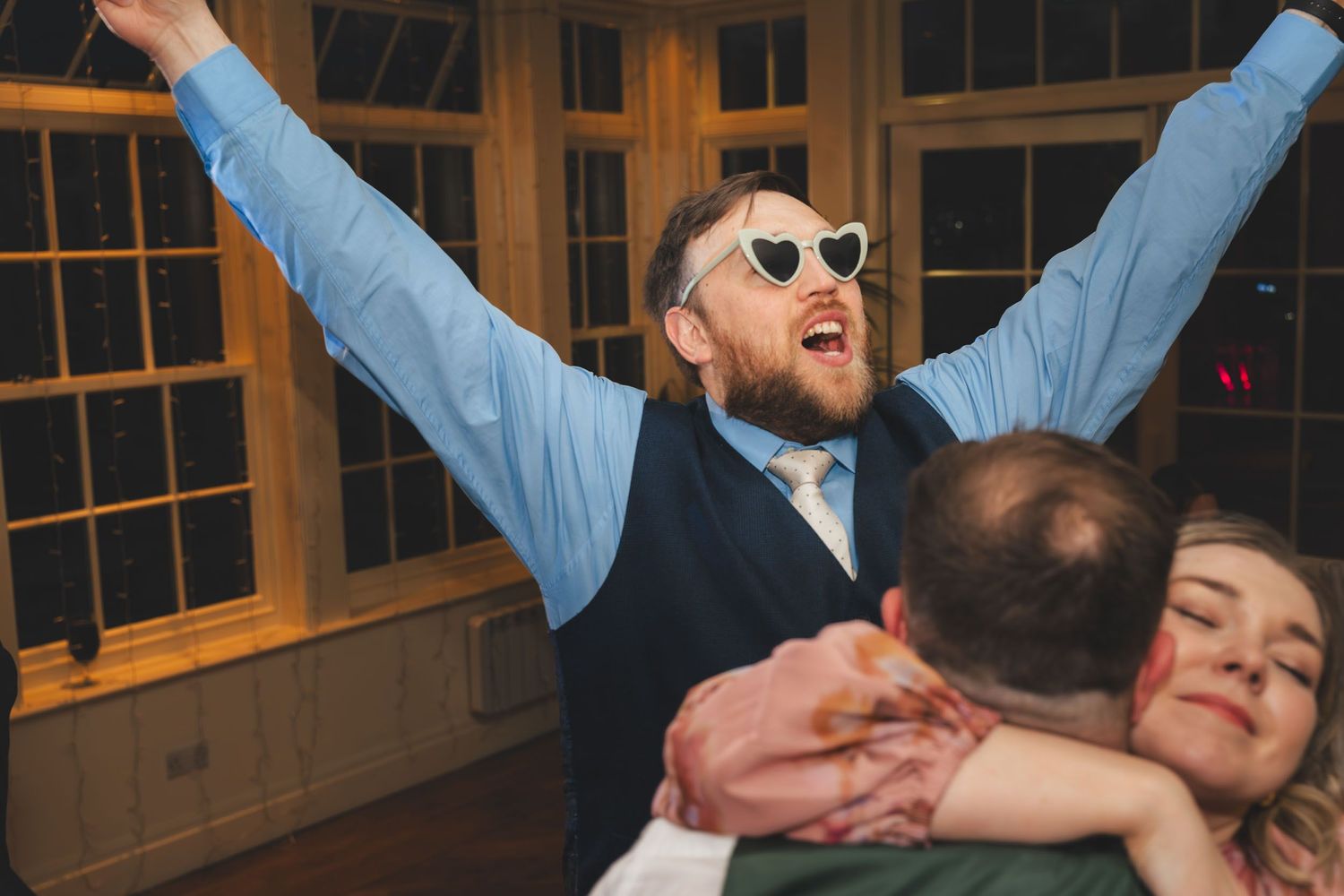 a wedding guest dances with his arms in the air in lancashire