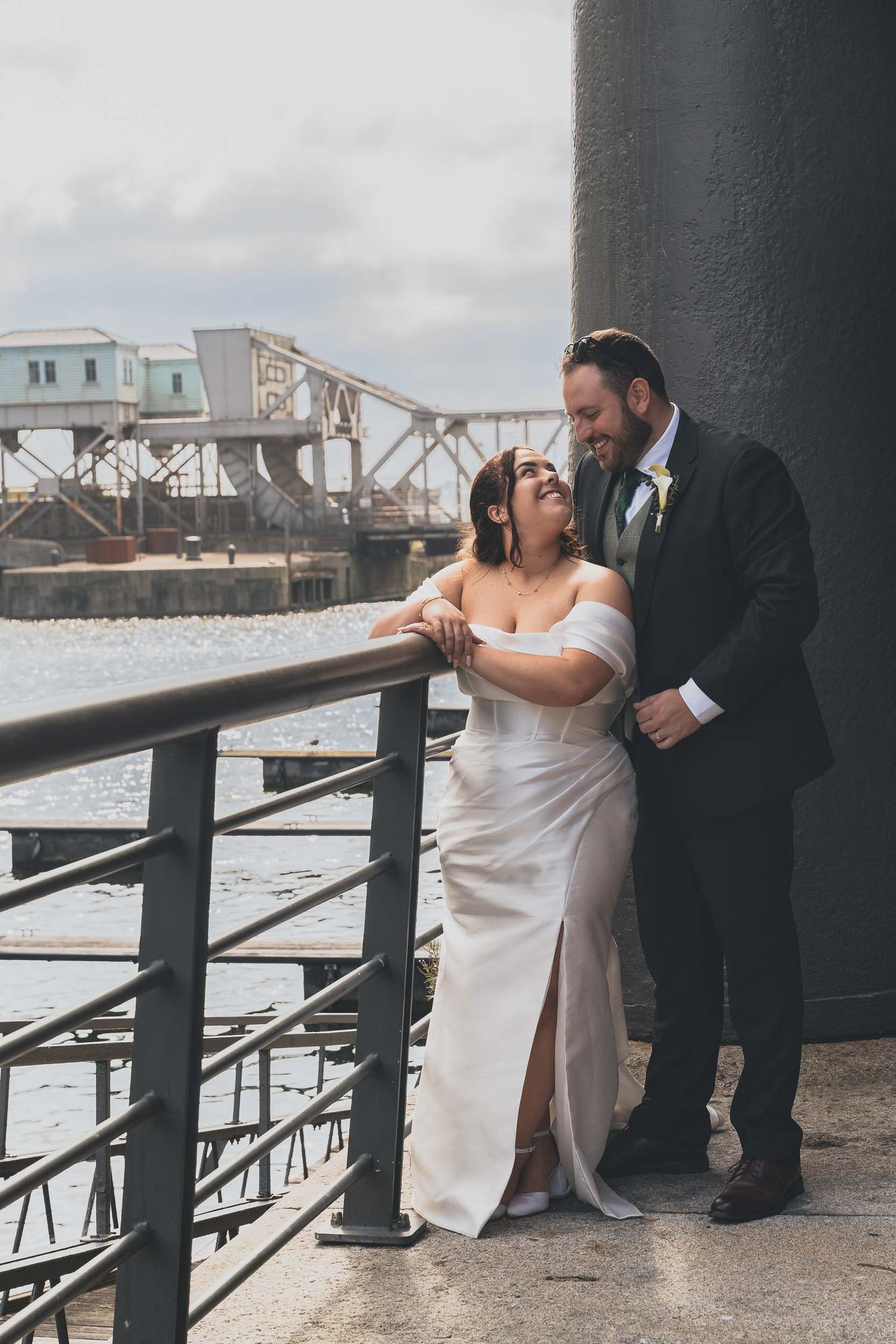 a bride and groom smile with Liverpool dicks visable behind them