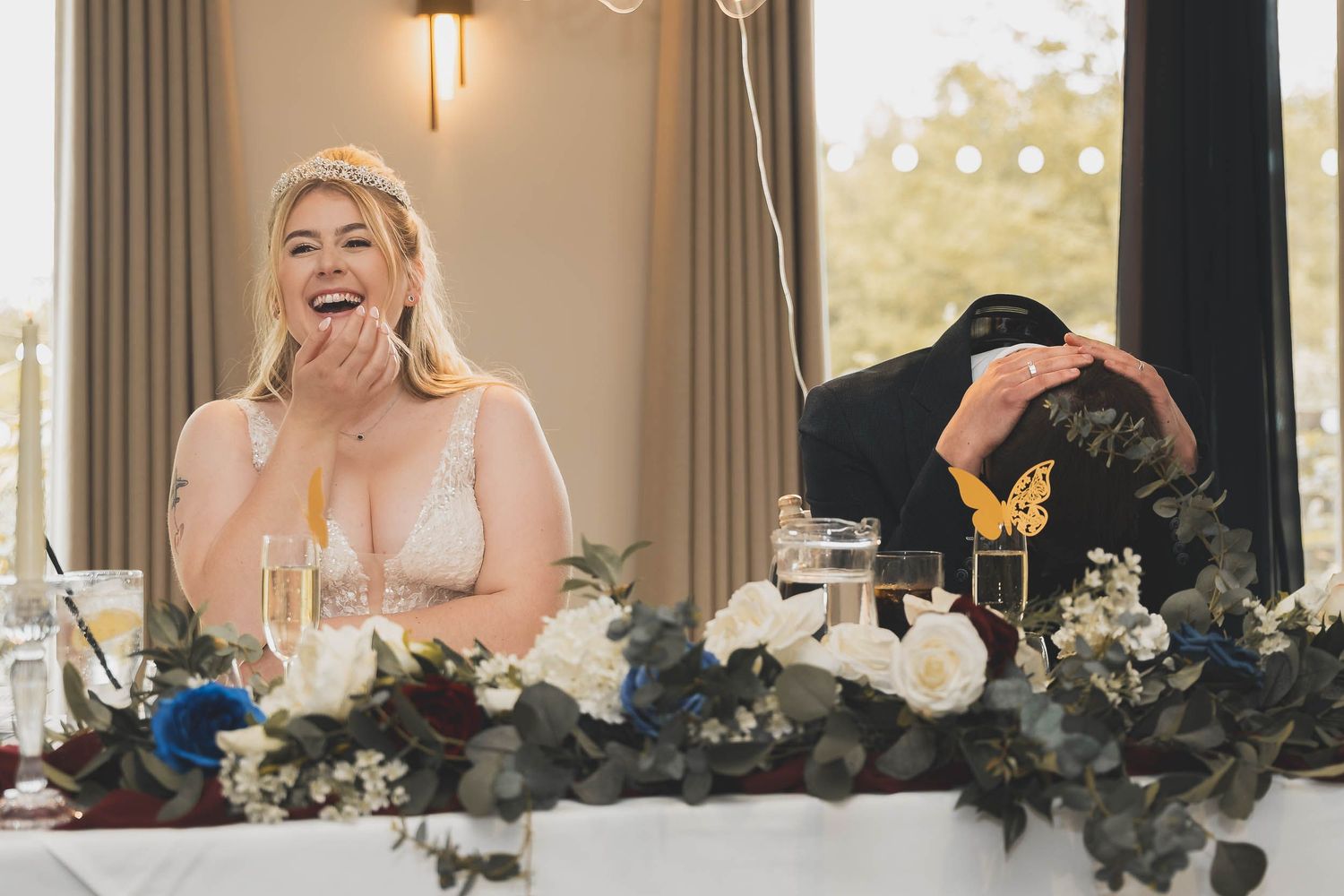 a bride laughs at a speech while the groom holds his head in his hands in sheffield
