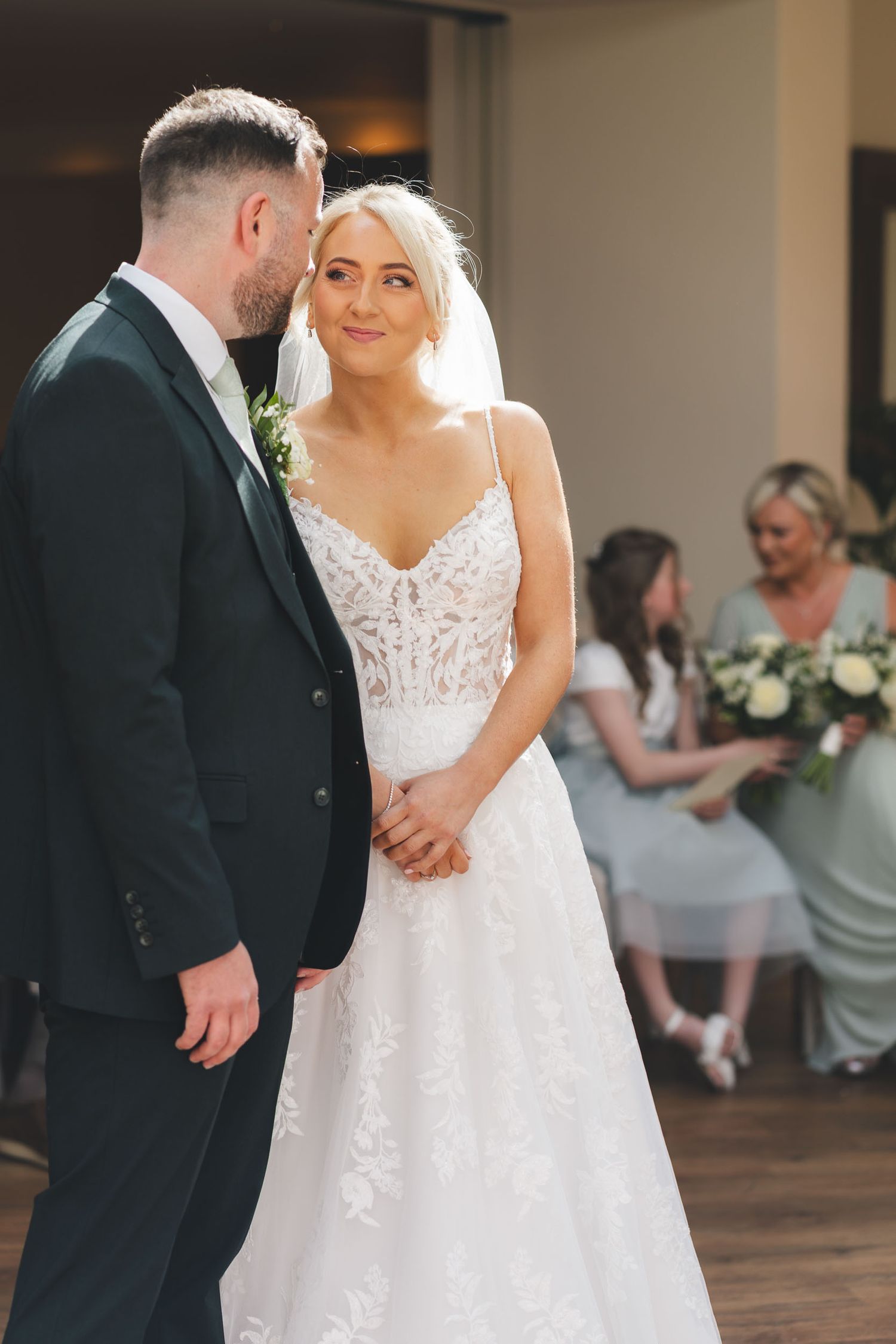 a bride smiles candidly at the groom during their ceremony in Clitheroe
