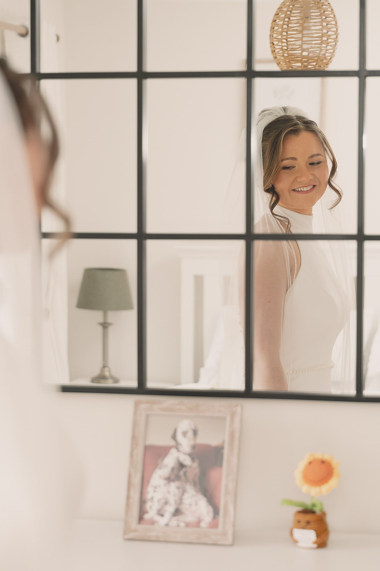 a bride smiles at a photograph of her dog at a wedding in Southport