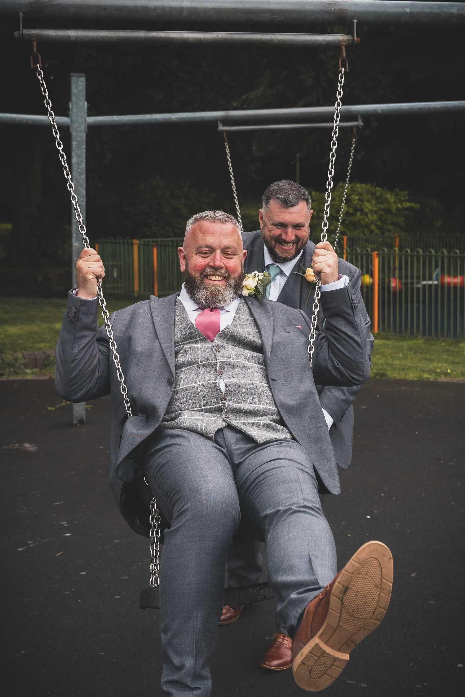 a groom being pushed on the swings at Victoria park in stoke