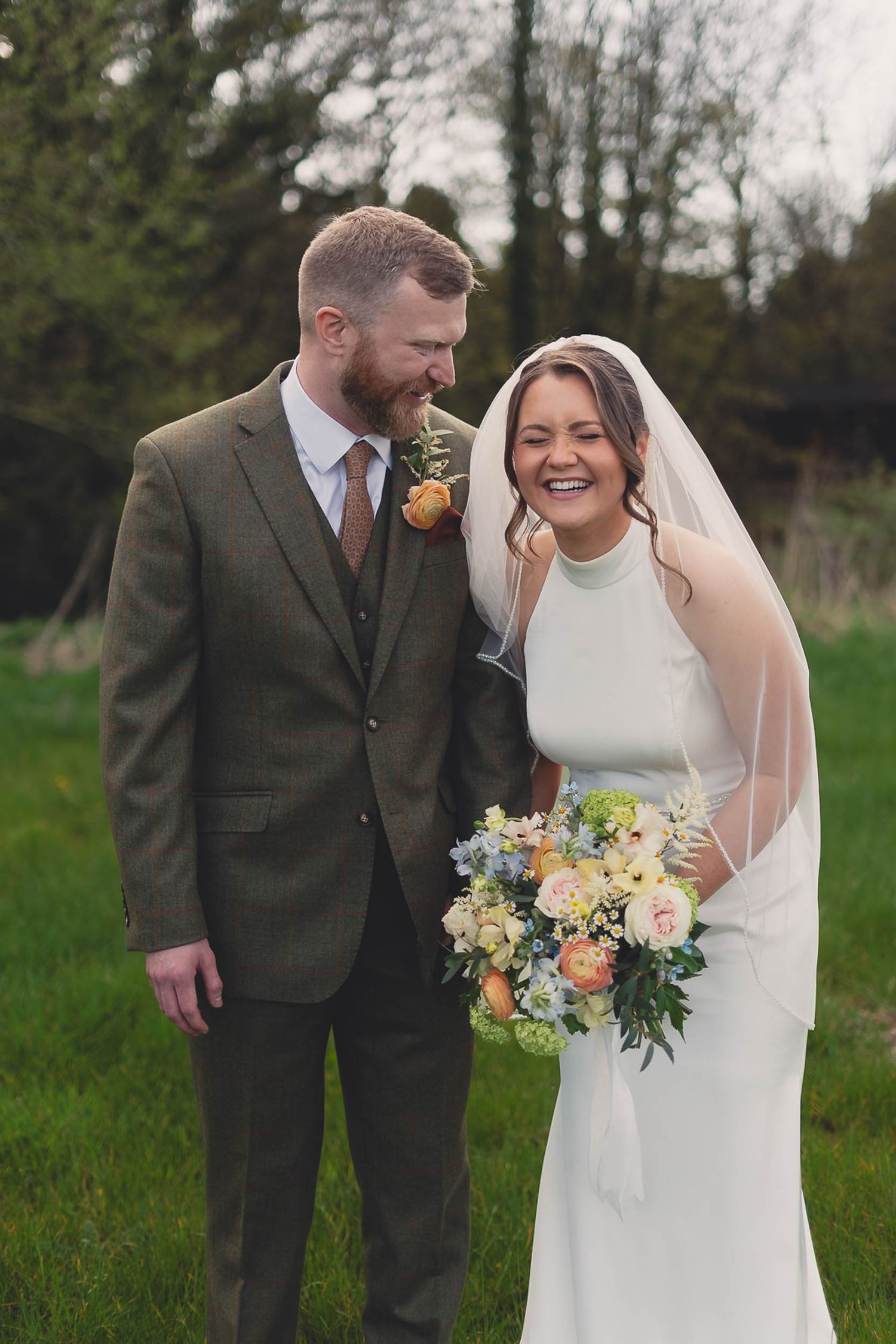 a bride and groom smile and laugh naturally at their wedding in Parbold