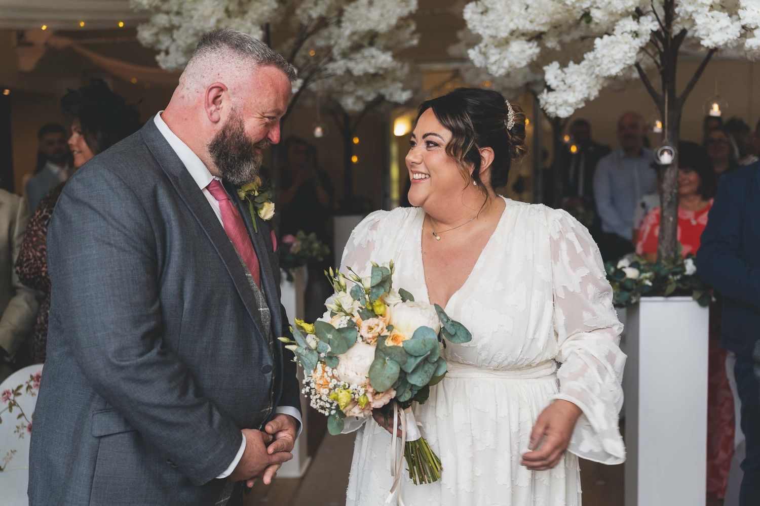 a bride and groom smile during their ceremony in stoke
