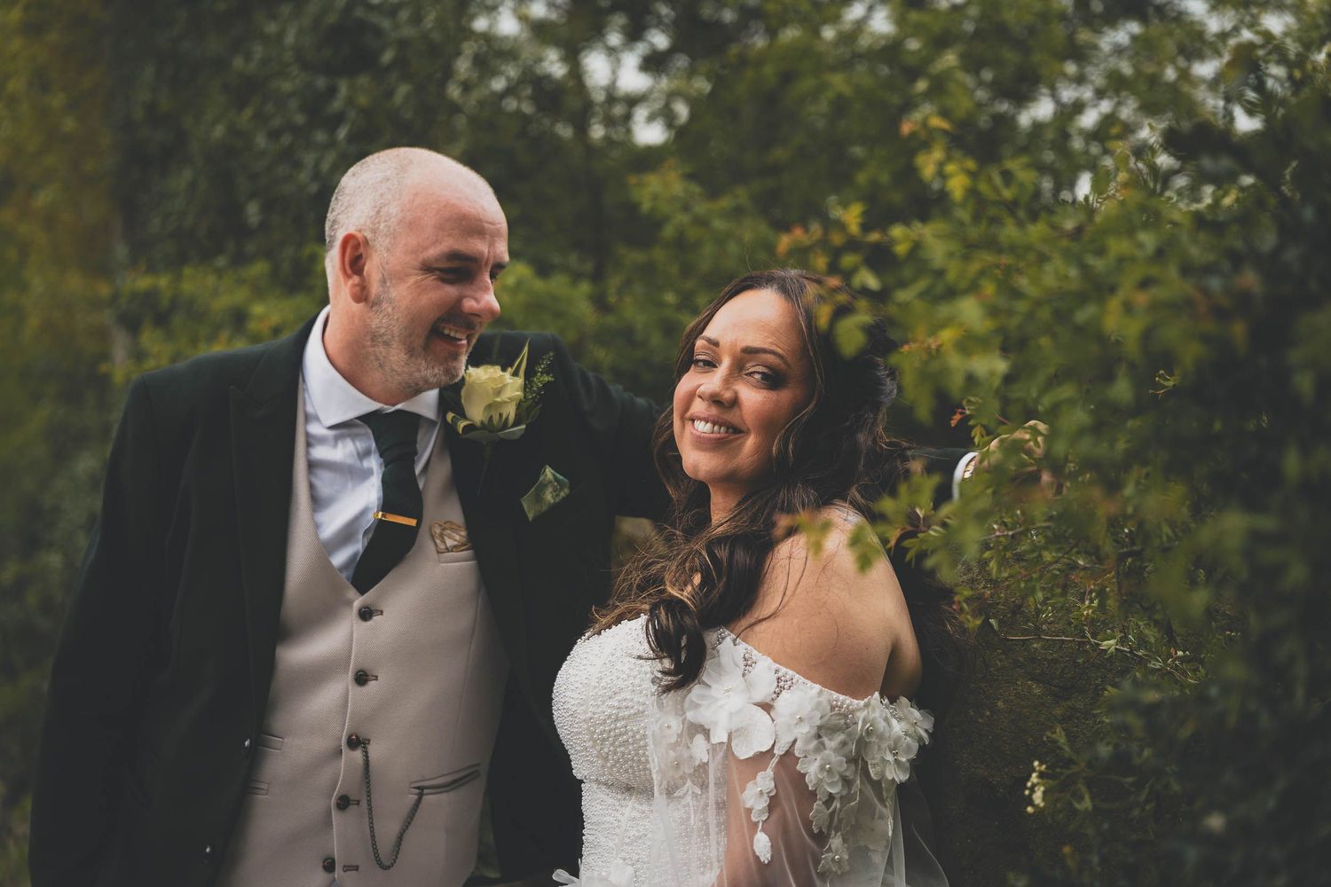 a bride and groom smile naturally at the Out Barn wedding venue near clitheroe
