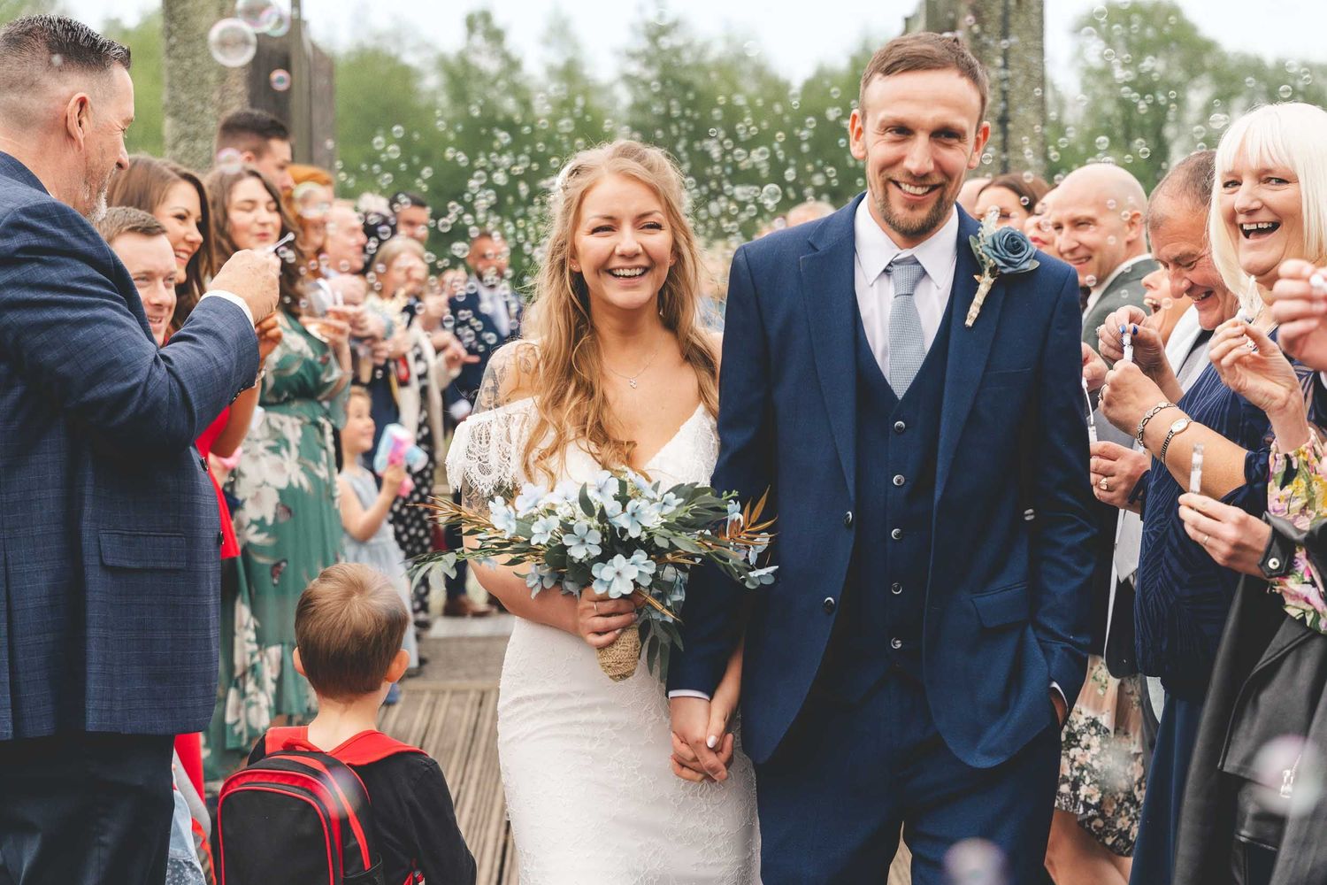a bride and groom walking through bubbles and confetti at Brockholes Nature Reserve wedding venue near Preston