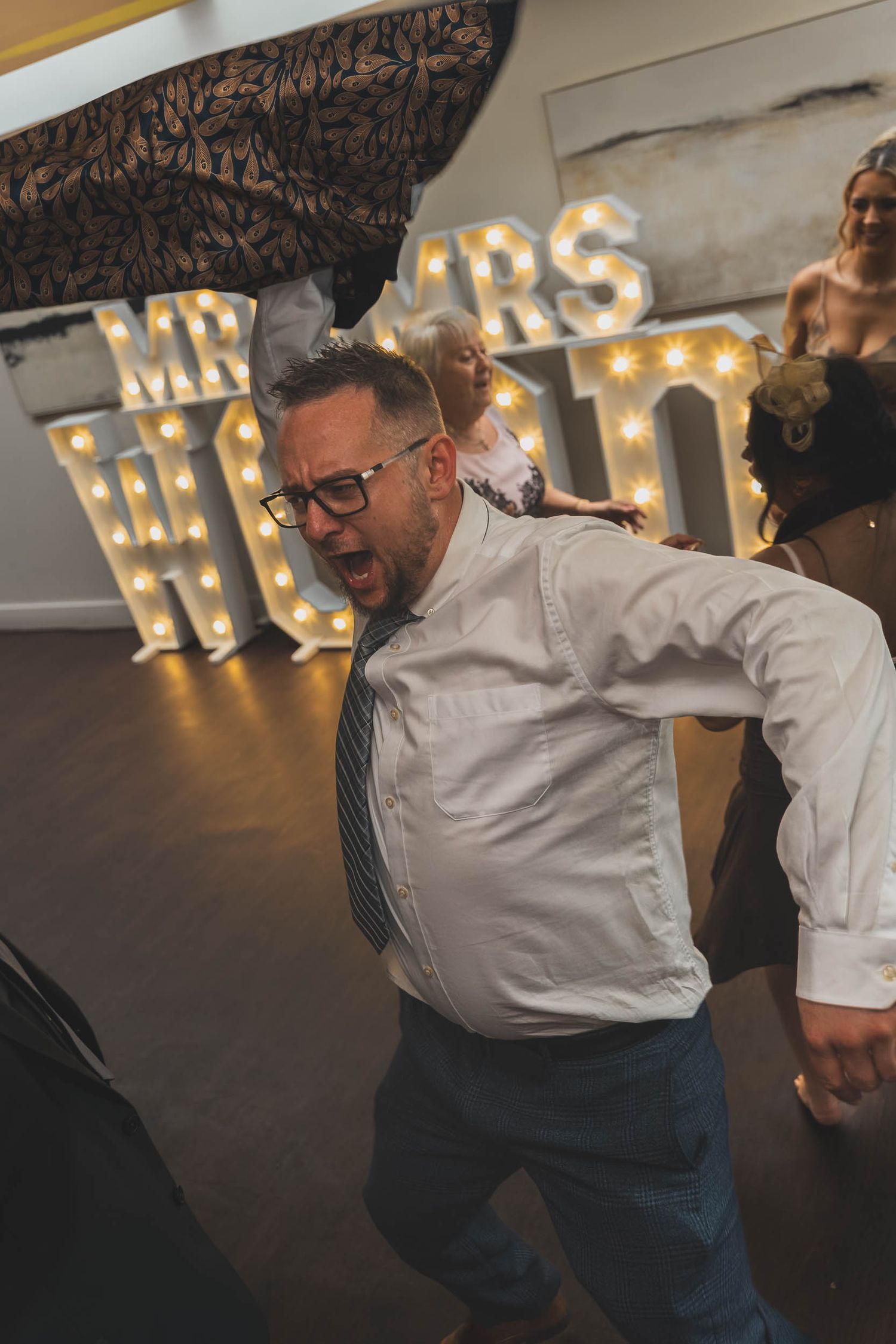 a wedding guest dancing and removing his jacket at a wedding in Sheffield