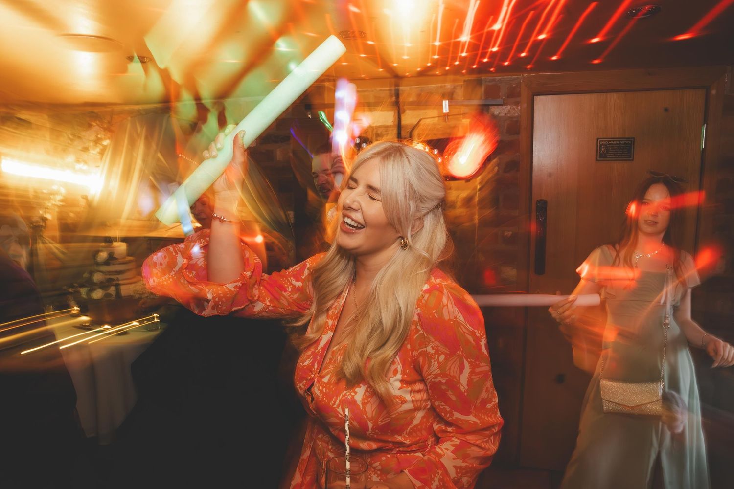 a wedding guest dancing with a glow stick at wedding in Telford