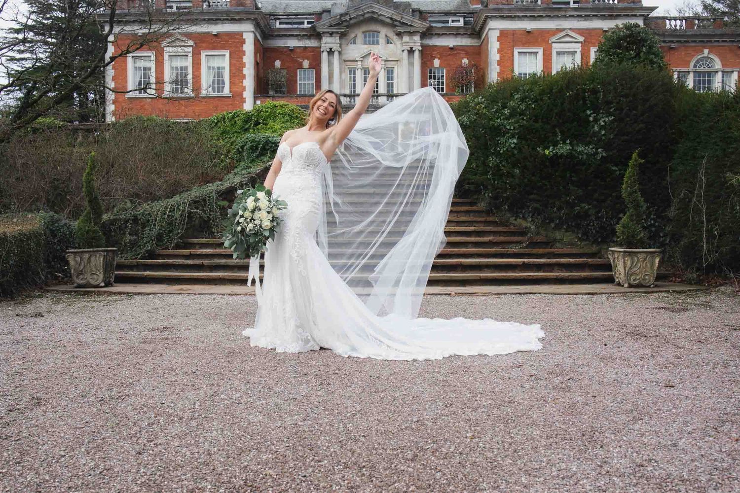 A bride poses in front of Eaves hall wedding venue in the Ribble Valley
