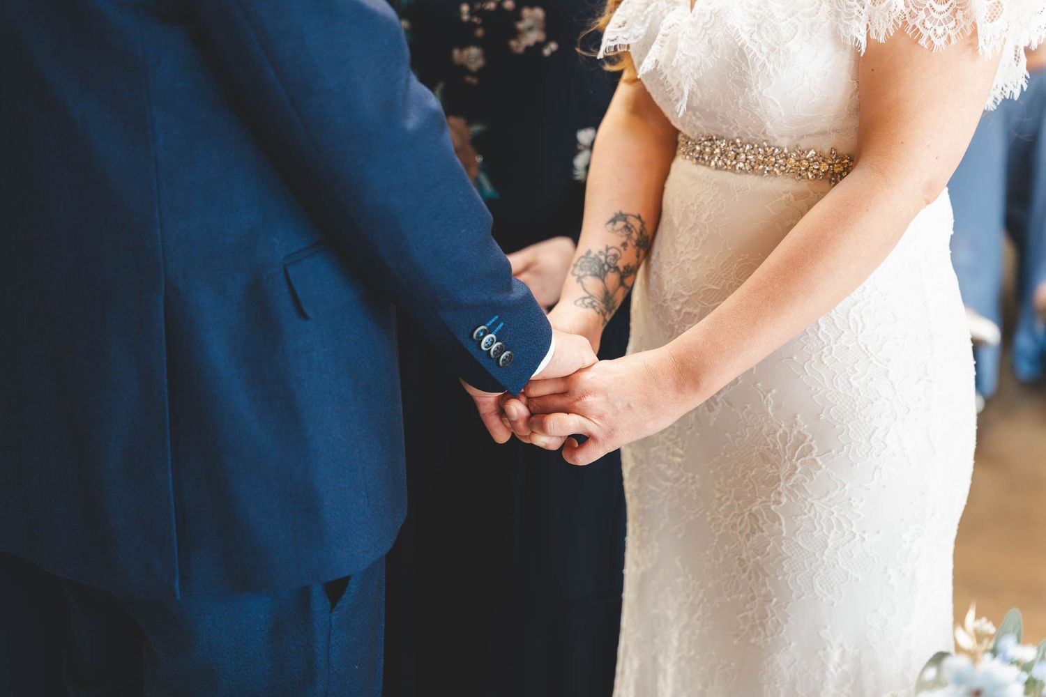 a bird and groom hold hands during their ceremony in Lancashire