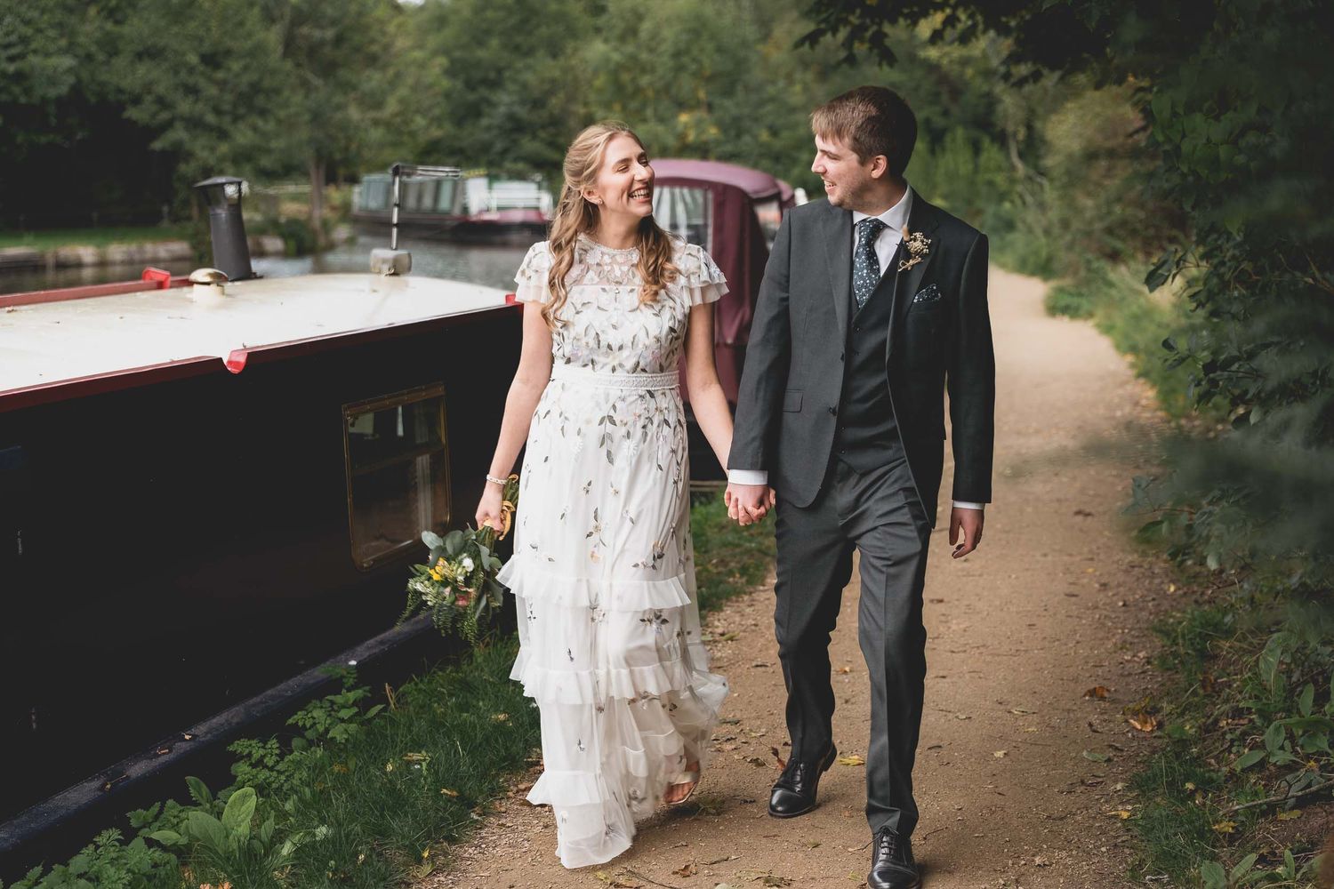 A bride and groom smoking naturally as they walk by the canal in Parbold