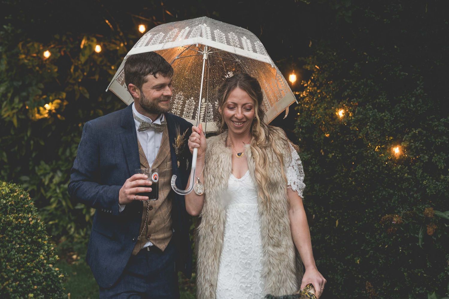 a bride and groom holding an umbrella at a wedding in county Durham