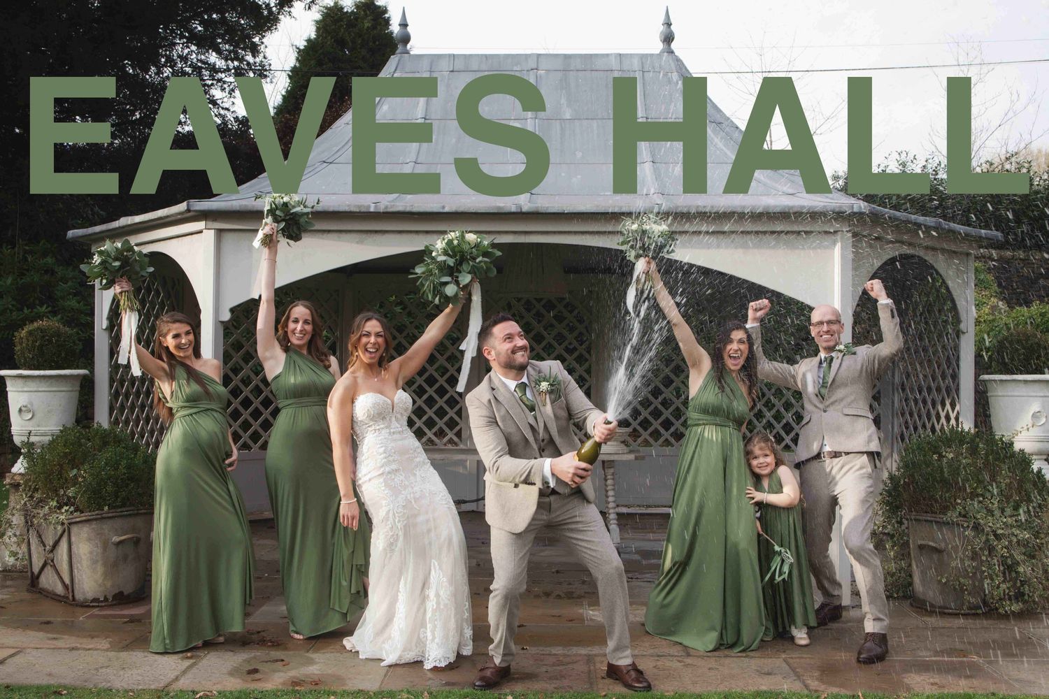A wedding party spraying champagne to celebrate getting married at eaves hall in clitheroe, lancashire