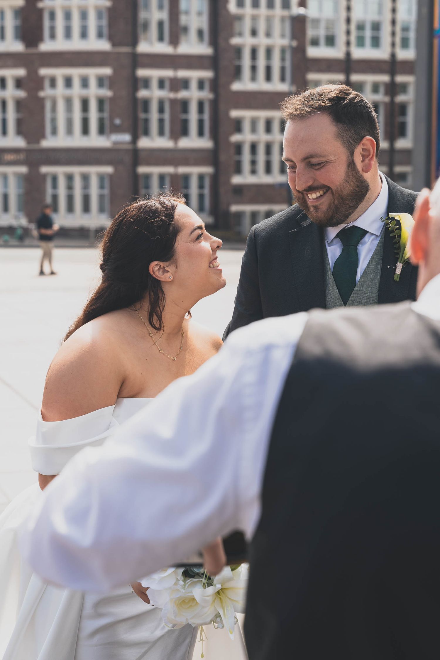 a bride and groom smile candidly at their wedding in Liverpool