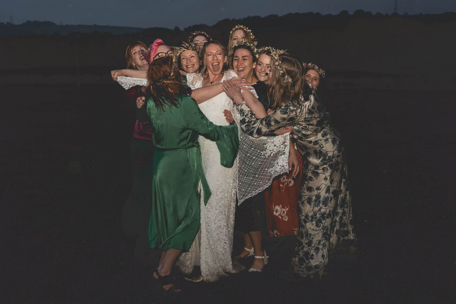 a bridal party cuddle in the rain at wedding in County Durham