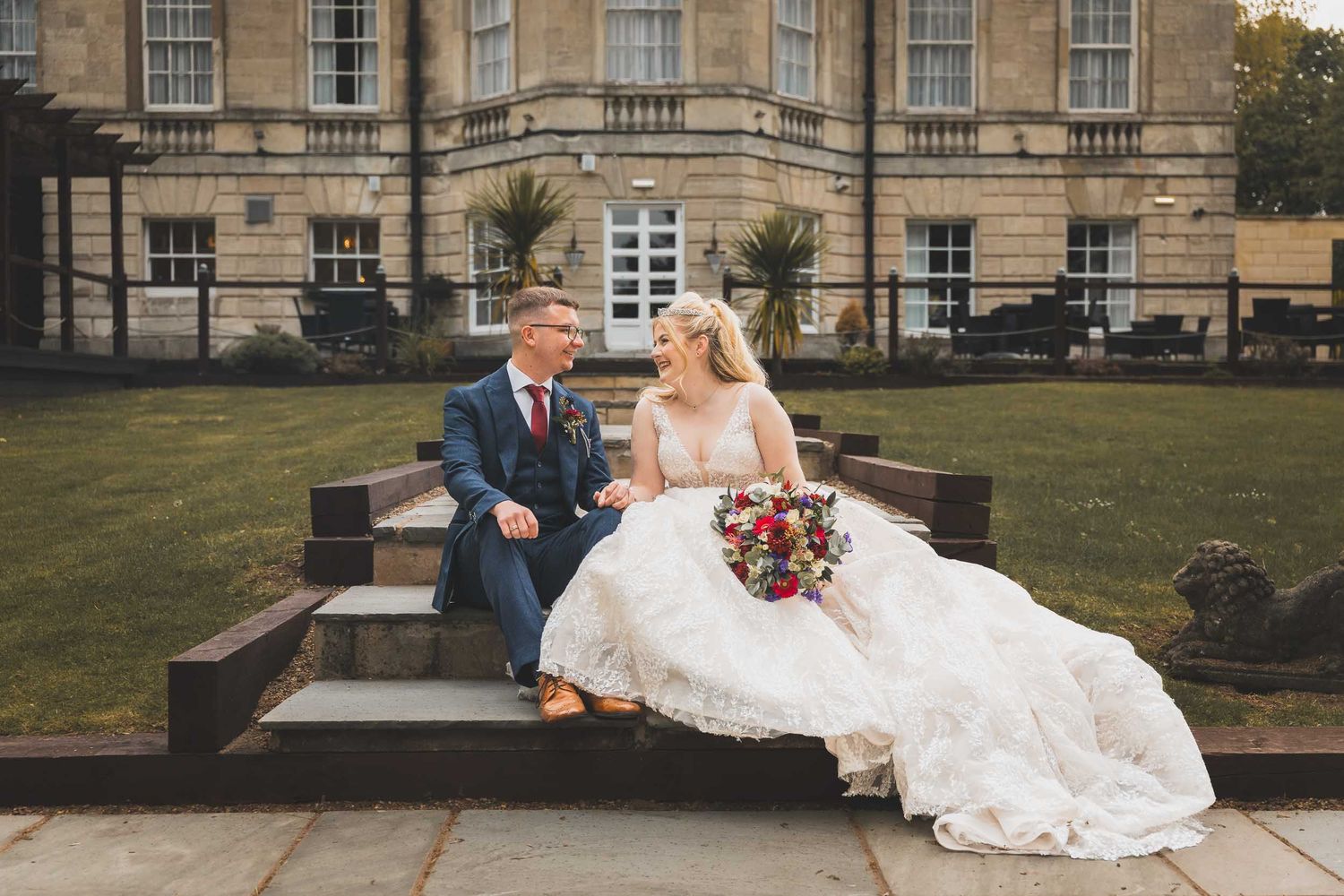 a bride and groom, sat outside Aston Hall wedding venue near Sheffield