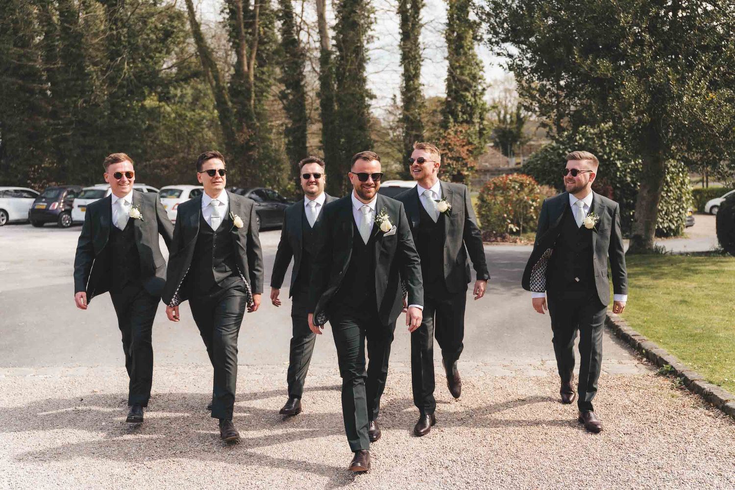 A groom and his groomsmen walking toward Mitton hall wedding venue in clitheroe