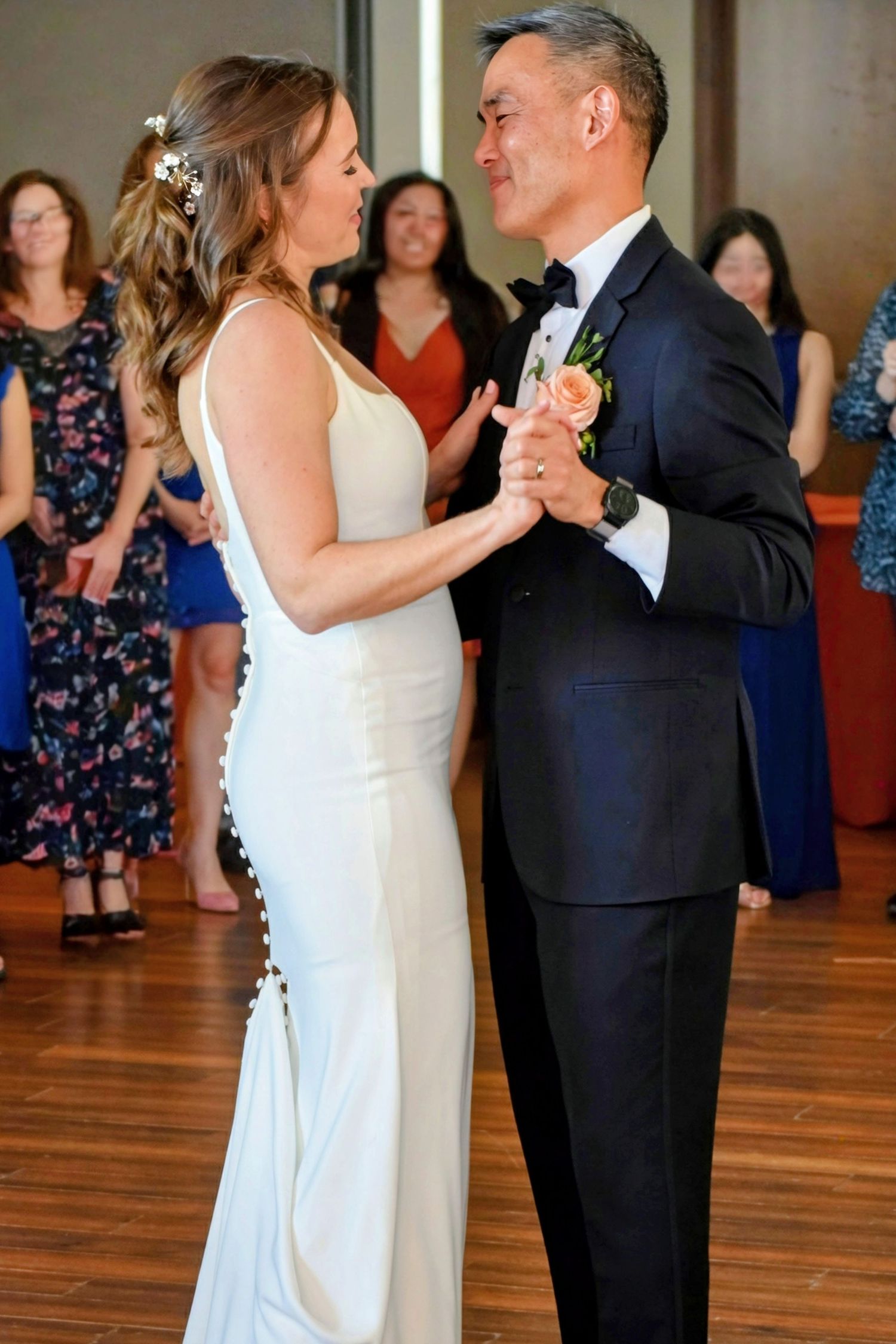 Smiling bride and groom share a romantic first dance at their wedding reception.