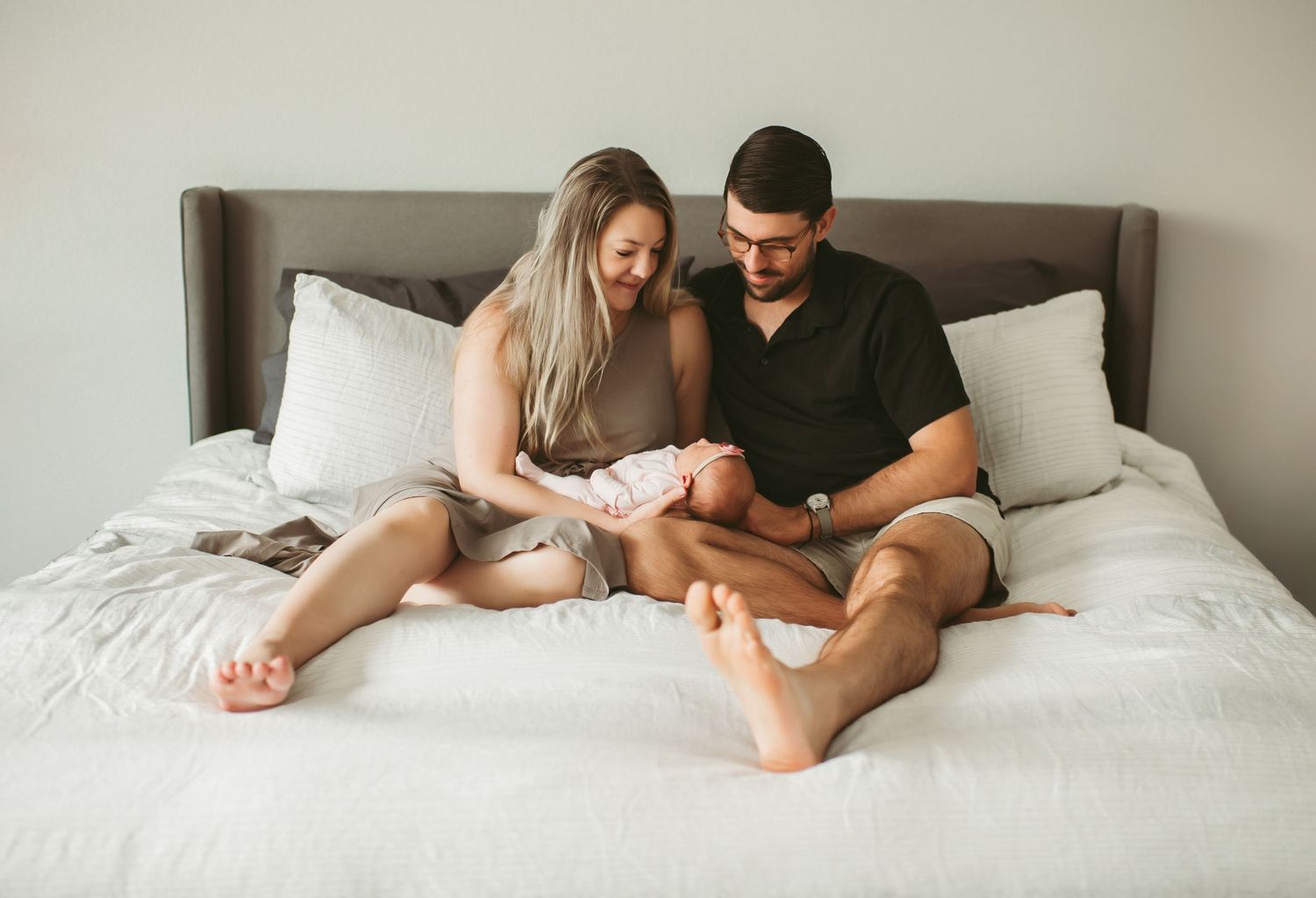 Brand new parents looking at their baby girl during a Lifestyle Newborn Session in their Suffolk, Virginia home.