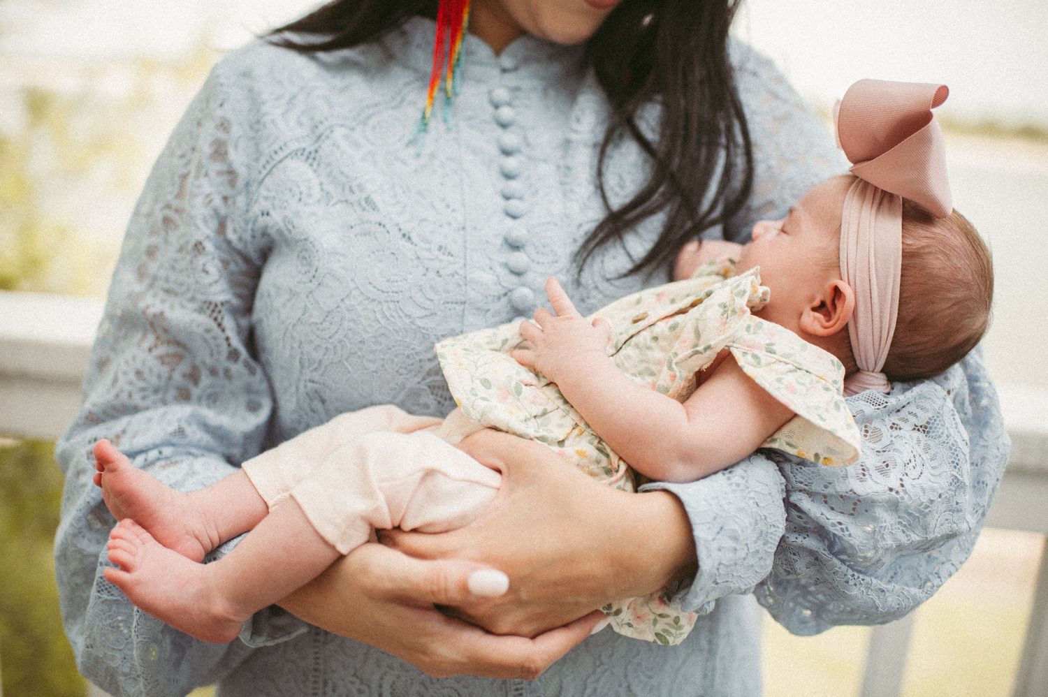 Norfolk, Virginia mom holding baby girl on their back deck during a newborn session.