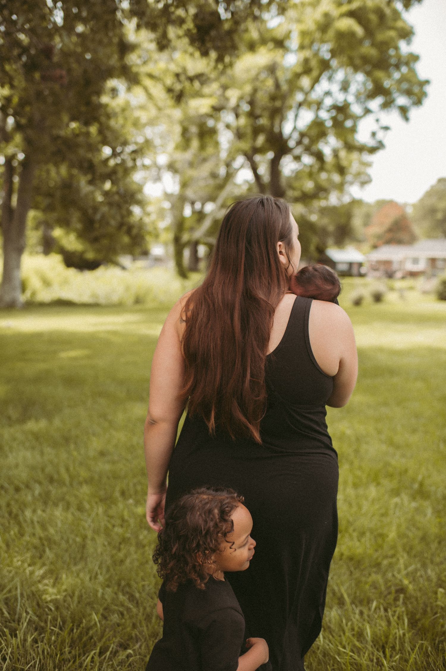 Suffolk, Virginia mom walking in her backyard with her two boys during a newborn session.