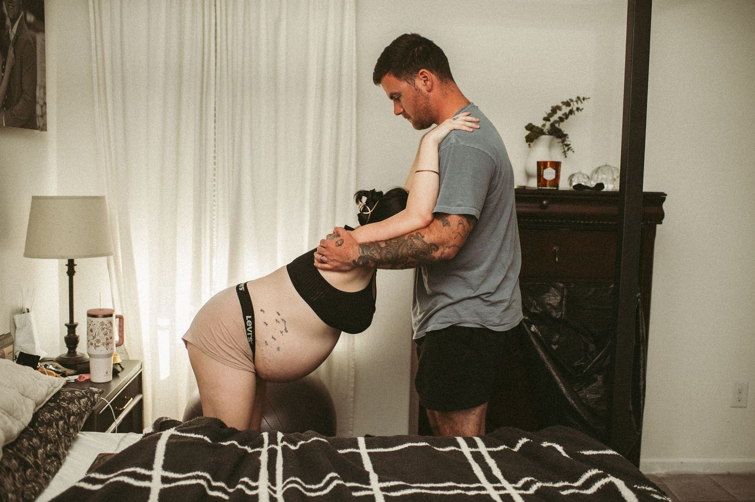 Husband supports his wife while she labors in their Suffolk, Virginia bedroom.