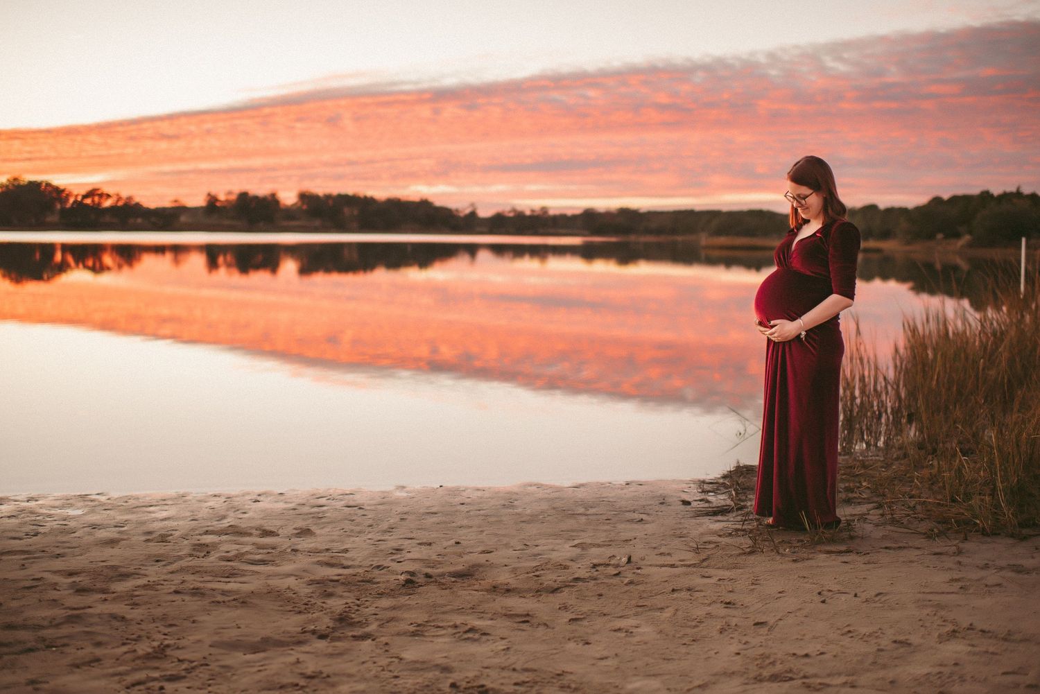 Expecting mom posing during her maternity session while the sun sets in Virginia Beach at a local Environmental Center.