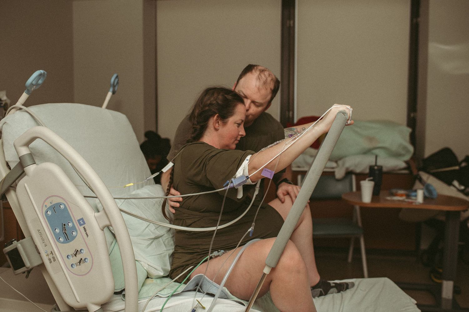 Partner supporting laboring mom while she pushes through contractions in a hospital room in Norfolk.