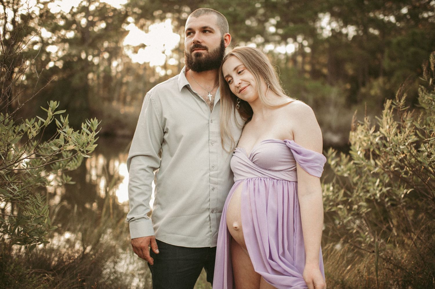 Expecting mom and dad share an embrace during their maternity session at a local Virginia Beach Environmental park.