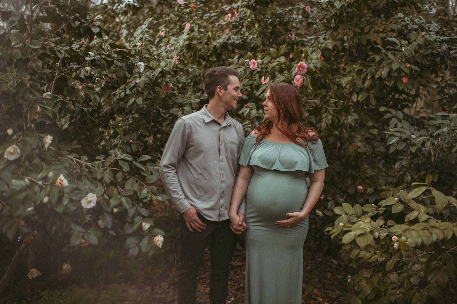 Expecting couple posing for a maternity photo in the garden of a local Chesapeake, Virginia park.