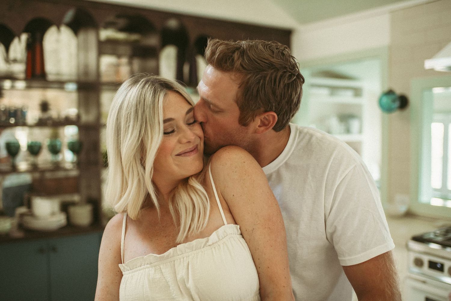 Virginia Beach maternity photographer capturing a moment between mom and dad sharing a tender kiss during their maternity session.